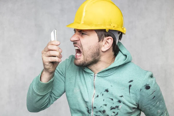 The building supervisor is shouting to a cell phone — Stock Photo, Image