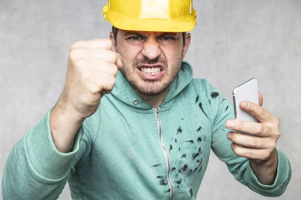 The building supervisor is shouting to a cell phone, front view — Stock Photo, Image