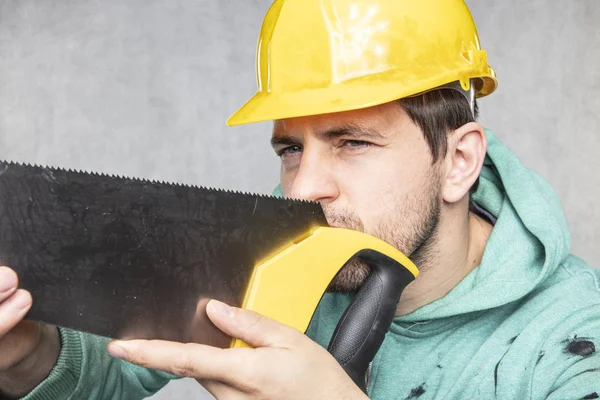 De bouwer controleert of de zaag recht is, vooraanzicht — Stockfoto