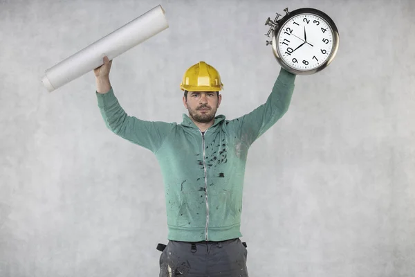 O construtor está segurando planos e um relógio em sua mão — Fotografia de Stock