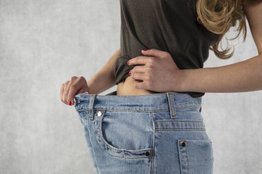 Genç ve güzel atletik kız ne kadar kilo verdiğini gösteriyor.