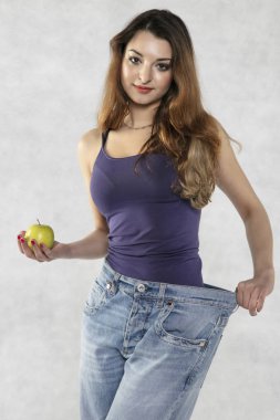 genç atletik kadın siluet, elma ve eski büyük pantolon
