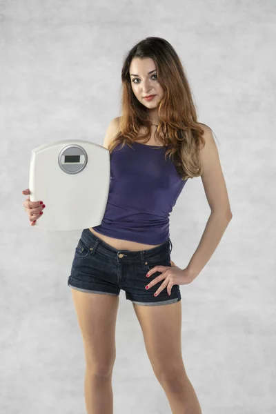 Jovem menina bonita com um peso, símbolo de perda de peso — Fotografia de Stock
