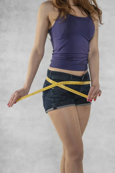 Mladá atletická silueta ženského pohlaví, měření pásky — Stock fotografie