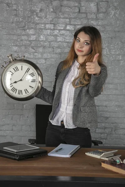 Business woman holding a big watch, thumb up — Stock Photo, Image