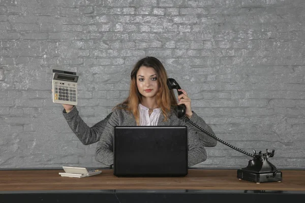 Jeune femme d'affaires multitâche assise au bureau — Photo