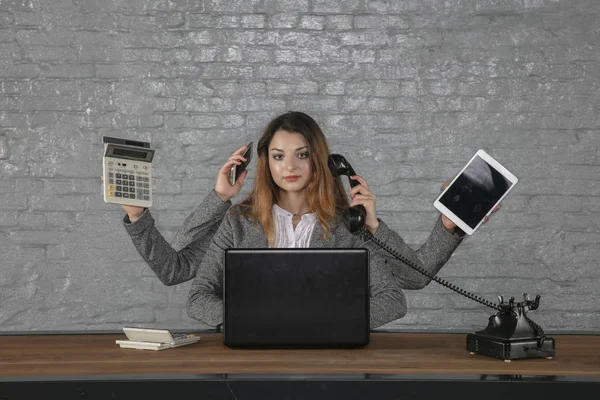 Multitasking zakelijke vrouw zittend op Bureau — Stockfoto