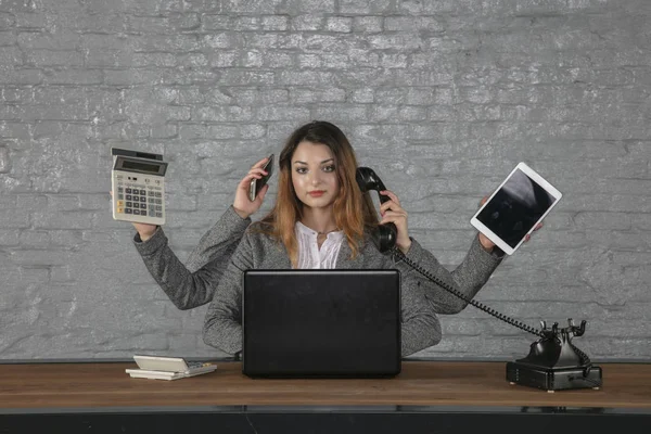 Multitasking mulher de negócios sentado na mesa — Fotografia de Stock