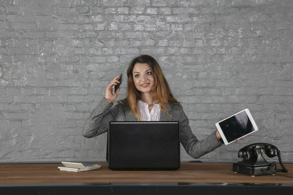 Young business woman talking on the phone, holding calculator in — Stock Photo, Image