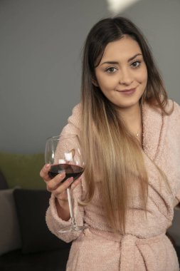 Sabahları bornozlu genç kız şarap içer.