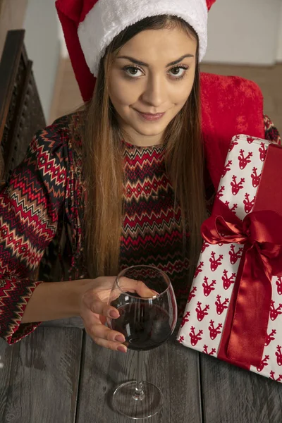 Jovem menina bonita envolve presentes para o Natal, beber vinho — Fotografia de Stock