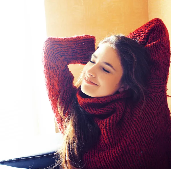 Young pretty real woman in sweater and scarf all over her face smiling at  home, winter positive Stock Photo by ©iordani 87858334
