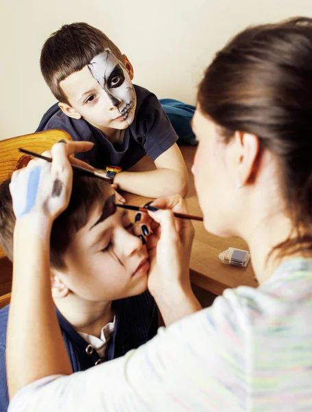 little cute child making facepaint on birthday party, zombie Apocalypse facepainting, halloween preparing concept, lifestyle people close up