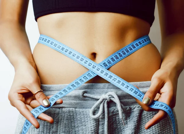 woman measuring waist with tape on knot like a gift