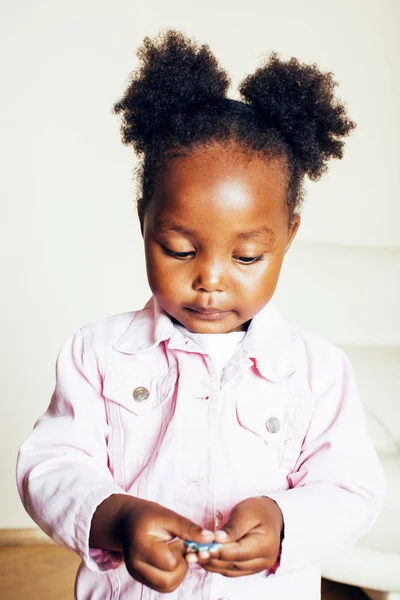 little cute african american girl playing with animal toys at home, pretty adorable princess in interior happy smiling, lifestyle people concept close up