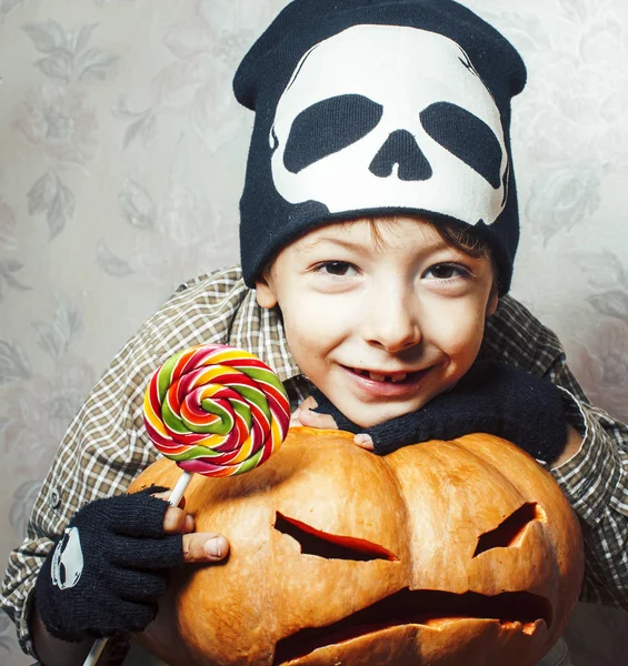 little cute boy in skeleton hat with pumpkin and candy at halloween party holiday, lifestyle people concept