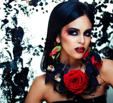 pretty brunette woman with rose jewelry, black and red, bright make up kike a vampire closeup red lips