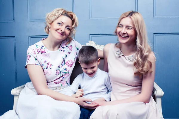 happy smiling blond family together posing cheerful on blue background, generation concept. lifestyle people