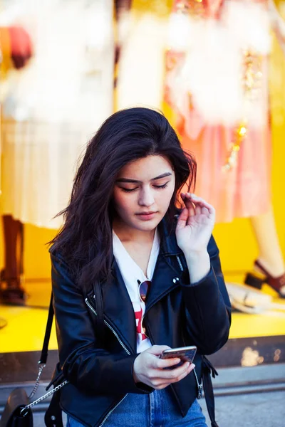 young pretty asian woman outside on big city street, lifestyle people concept