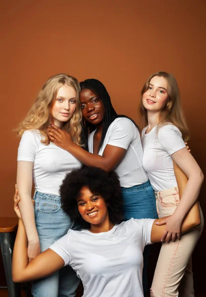 young pretty asian, caucasian, afro woman posing cheerful together on brown background, lifestyle diverse nationality people concept