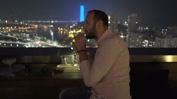 Hombre Joven Relajante Y Beber Cócteles Sentada En La Terraza En Bar Por La Noche