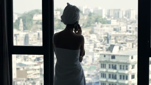 Femme Heureuse Serviette Parlant Sur Téléphone Portable Debout Près Fenêtre — Video