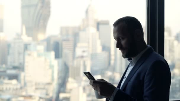 Biznesmen Picia Napojów Sms Smartphone Przez Okna Biurze — Wideo stockowe