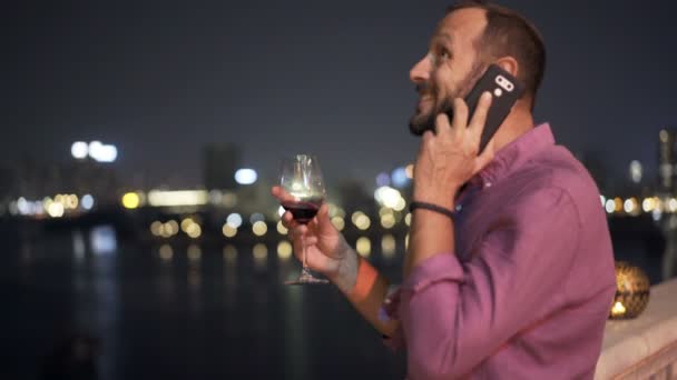 Joven Hablando Por Celular Bebiendo Vino Terraza Bar Por Noche — Vídeo de stock
