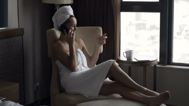 Szczęśliwa Kobieta Rozmowy Telefon Komórkowy Picie Kawy Fotel Przy Oknie — Wideo stockowe