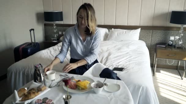 愉快的女实业家在早餐在床上的食物照片在酒店 — 图库视频影像