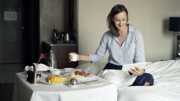 Affärskvinna Titta Film Tablett Och Äta Frukost Hotellrum — Stockvideo