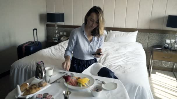 Attraktiva Affärskvinna Textning Smartphone Och Äter Frukost Hotellrum — Stockvideo