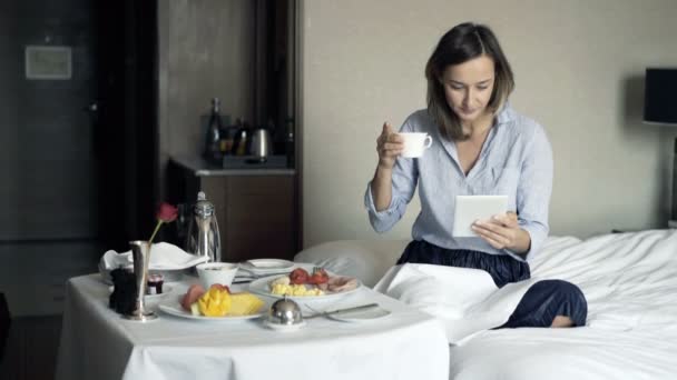 Aantrekkelijke Zakenvrouw Met Tablet Tijdens Het Ontbijt Hotelkamer — Stockvideo