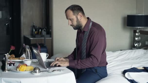 ホテルの朝食時にラップトップ上の仕事を終えた青年実業家 — ストック動画
