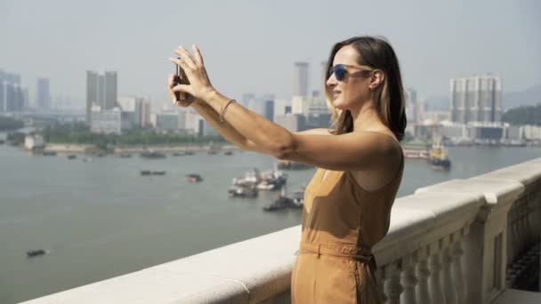 Jonge Vrouw Met Foto Van Stadsgezicht Met Cellphone Staan Terras — Stockvideo