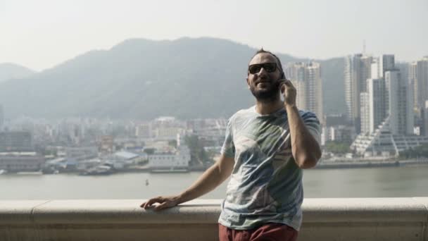 Joven Hablando Por Celular Parado Terraza Ciudad — Vídeo de stock