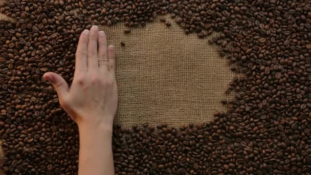 Inscription of word coffee appeared with female hand swinging. Jute with beans — Stock Video