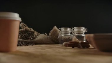 Kahveli tek kullanımlık kağıt bardakları topluyorum. Kadın eli içkiyi götürüyor.