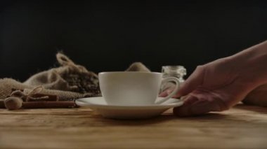 Kadın eli porselen bir fincan sıcak kahve koyar. Kahvede garsonluk.