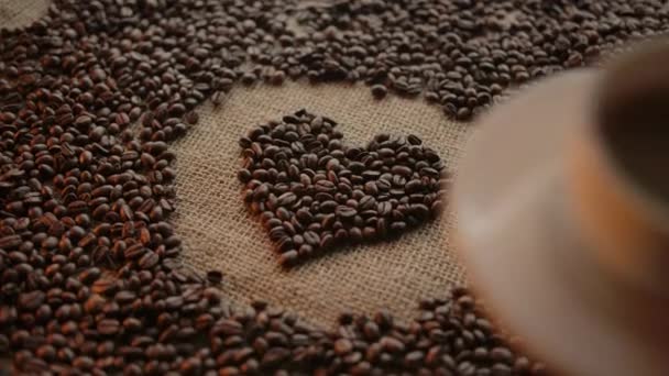 Transition from heart made of coffee beans to modern coffee sup served — Stock Video