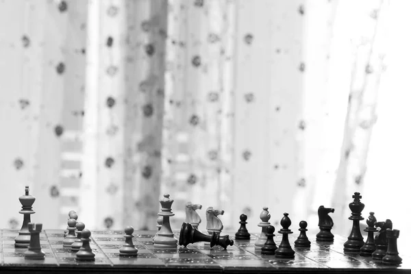 Relógio e peças de xadrez em um tabuleiro de xadrez como pano de fundo o  conceito de jogar e ganhar uma turnê de xadrez