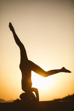 Genç kadın batımında yoga dağda pratiği yapıyor. Pratik yoga açık genç kadın silüeti.