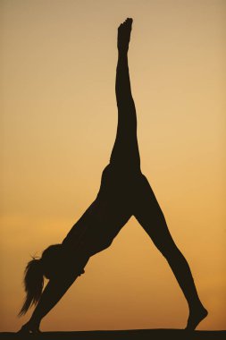 Genç kadın batımında yoga dağda pratiği yapıyor. Pratik yoga açık genç kadın silüeti.