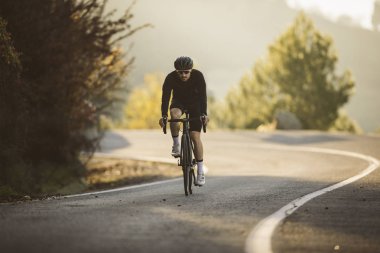 Profesyonel yol bisiklet yarış eylem içinde. Erkek dağ yol bisikleti günbatımında Bisiklete binme.