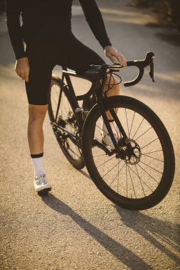 Profesyonel yol bisiklet yarışçısı poz. Erkek dağ yol bisikleti günbatımında Bisiklete binme.