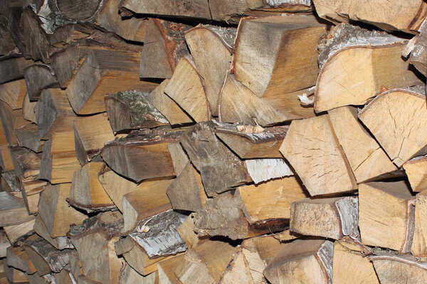 wooden logs are stacked in a woodpile. Close up photo.
