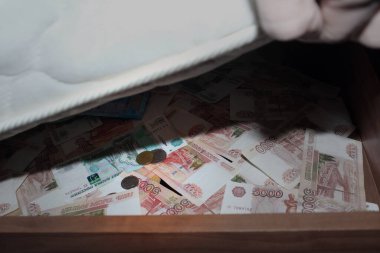 Yatağın altına para koymak. Rus rublesi banknotlarda ve paralarda gizlidir..