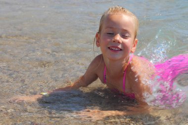 Deniz dalgalarında küçük bir kız.