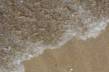 Yumuşak deniz sörfü kumlu sahilde koşar. Plaj fotoğrafı.