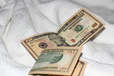 Beyaz bir yatak örtüsünün üzerinde Amerikan doları yatıyor.